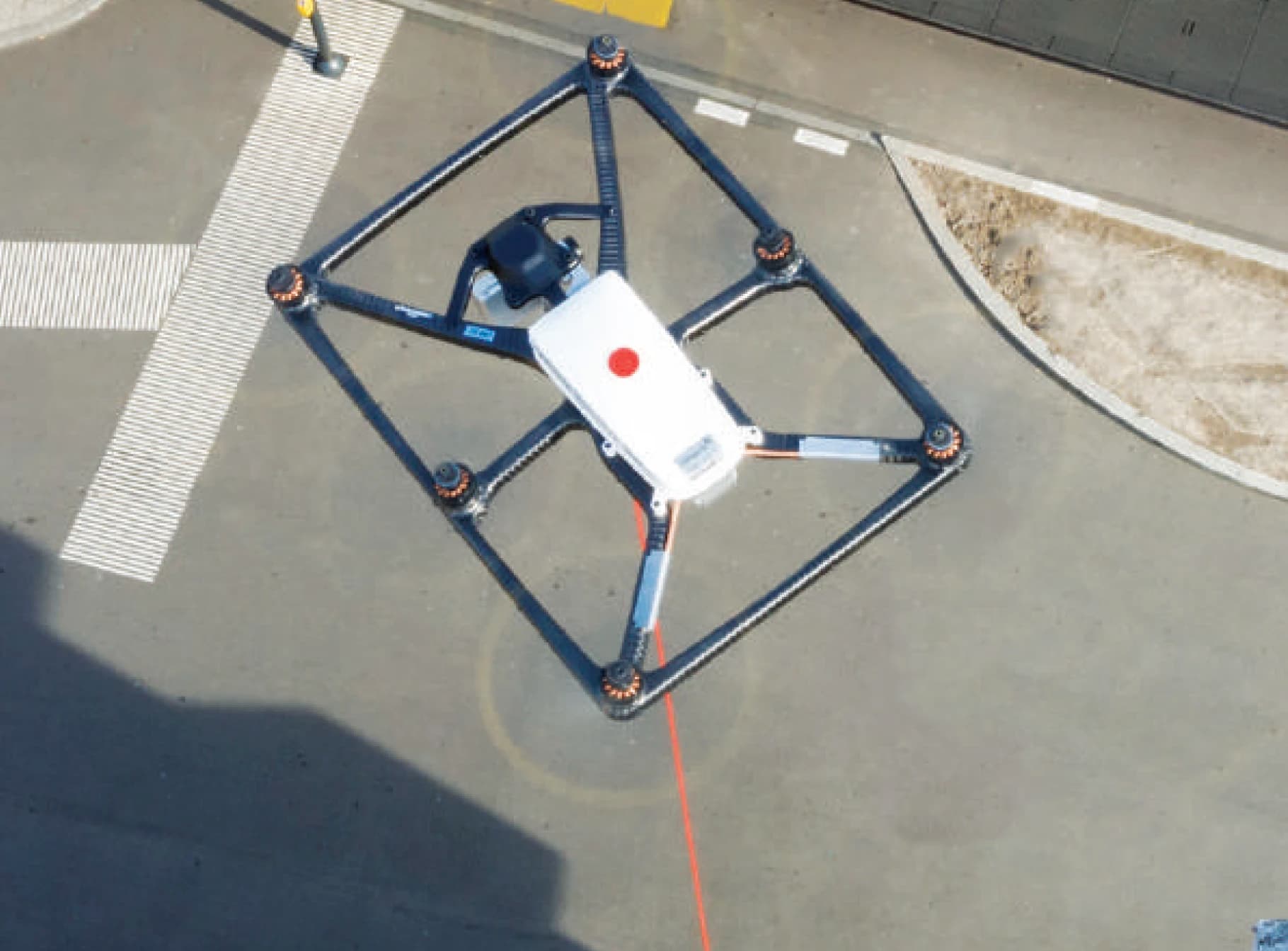 ATLAS tethered drone aerial view on facility tarmac with red tether